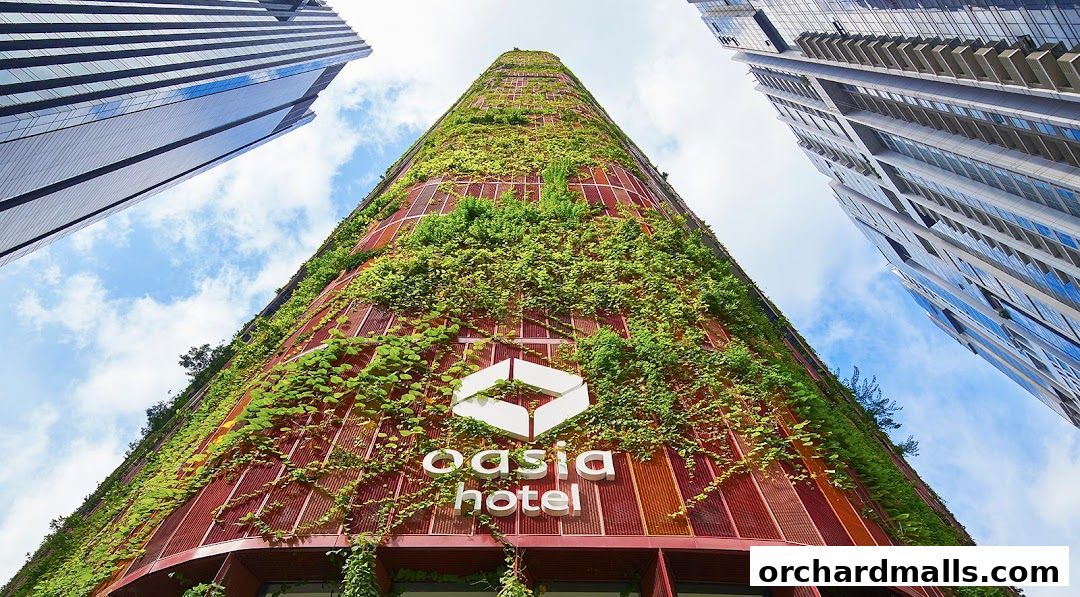 A striking view of the Oasia Hotel's facade, covered in lush greenery, against a blue sky.