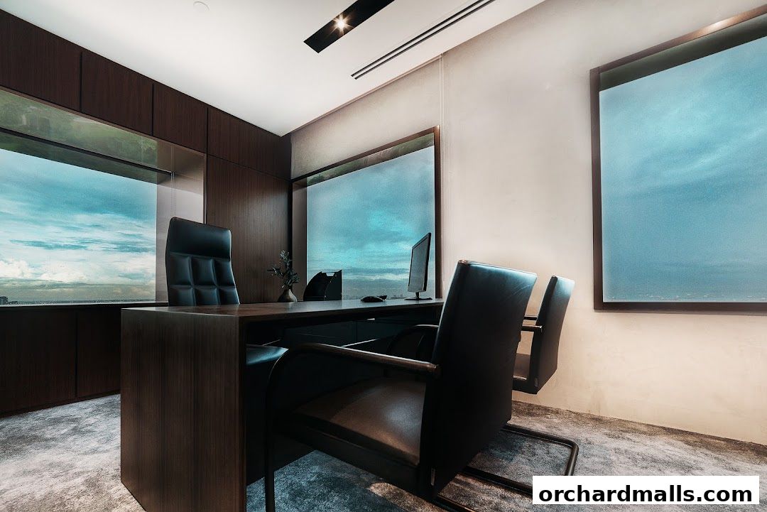 A modern office with a large desk, executive chairs, and a scenic view.