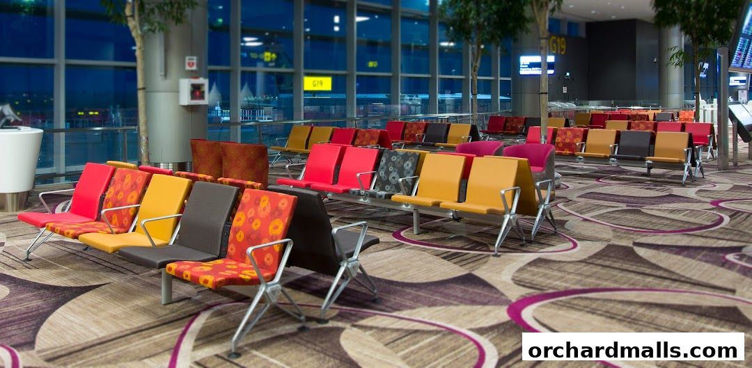 Modern airport waiting area with colorful seats and large windows.