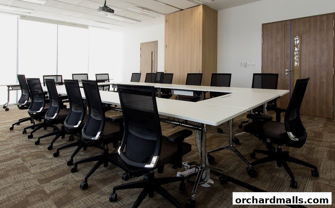 A modern conference room with a large U-shaped table and ergonomic chairs.