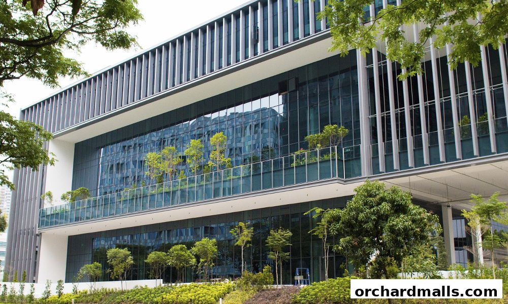 Modern office building with glass facade and lush greenery on balconies.