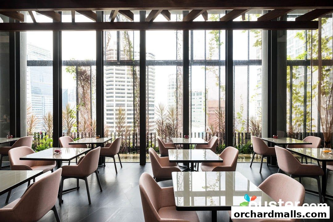 Interior of a modern restaurant with pink chairs and tables overlooking a city skyline.