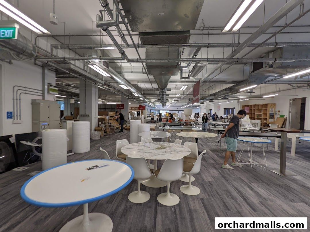 Interior view of a spacious retail store with various tables and chairs on display.
