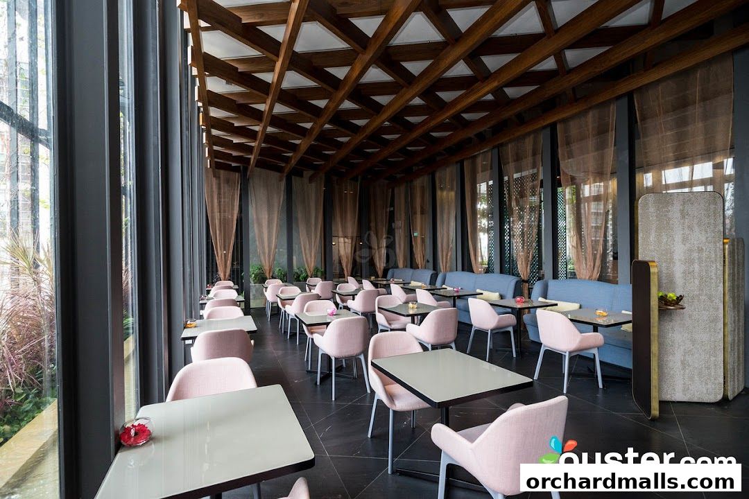 Interior of a modern restaurant with stylish pink chairs and wooden ceiling.
