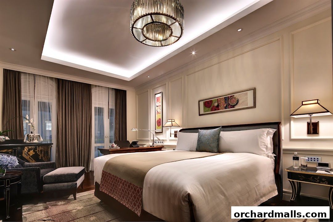 A luxurious hotel room with a king-size bed, elegant furnishings, and a chandelier.