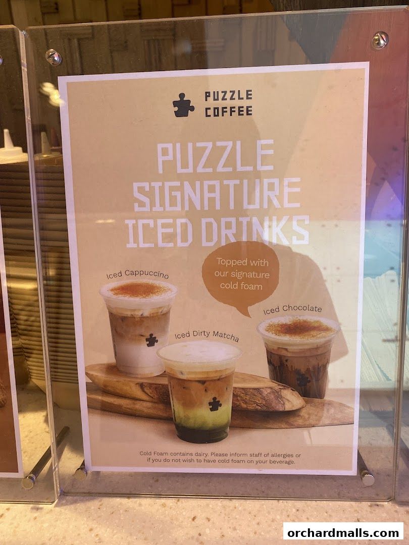 A sign showcasing Puzzle Coffee's signature iced drinks with cold foam.