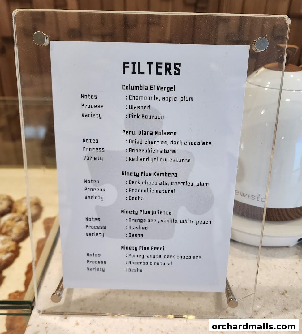 A menu board displaying different coffee filter options with tasting notes and processing details.