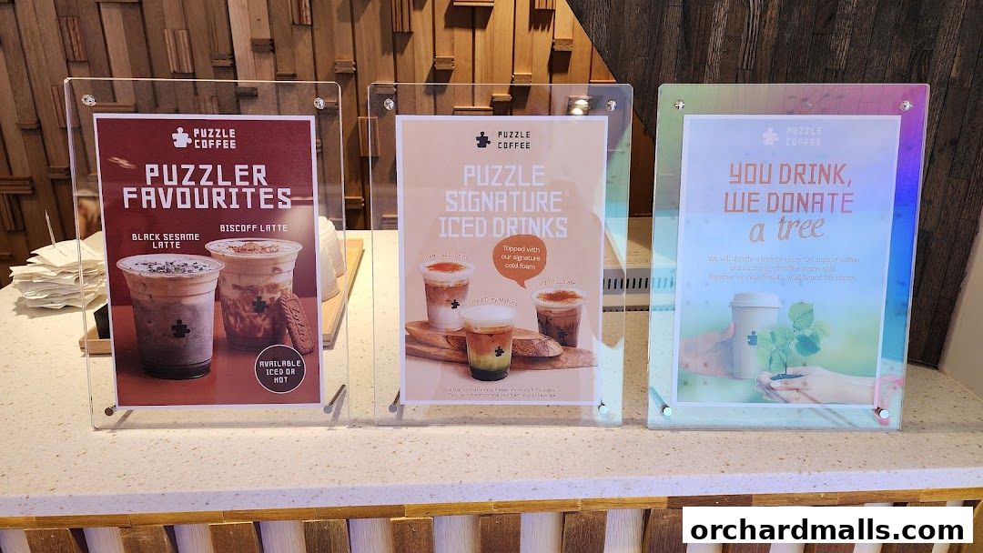 Three signs display coffee shop offerings and a tree donation initiative.