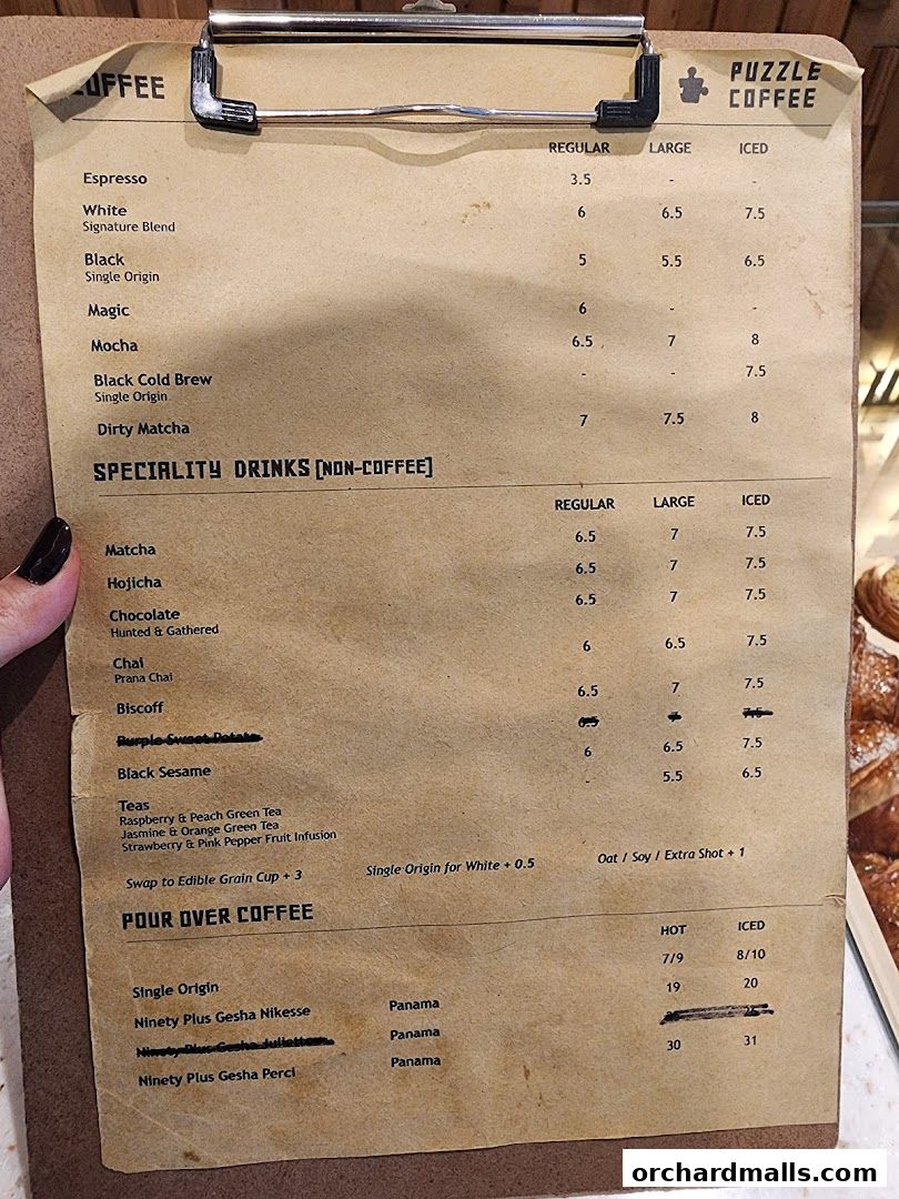 A close-up view of a coffee shop menu with various coffee and specialty drink options.