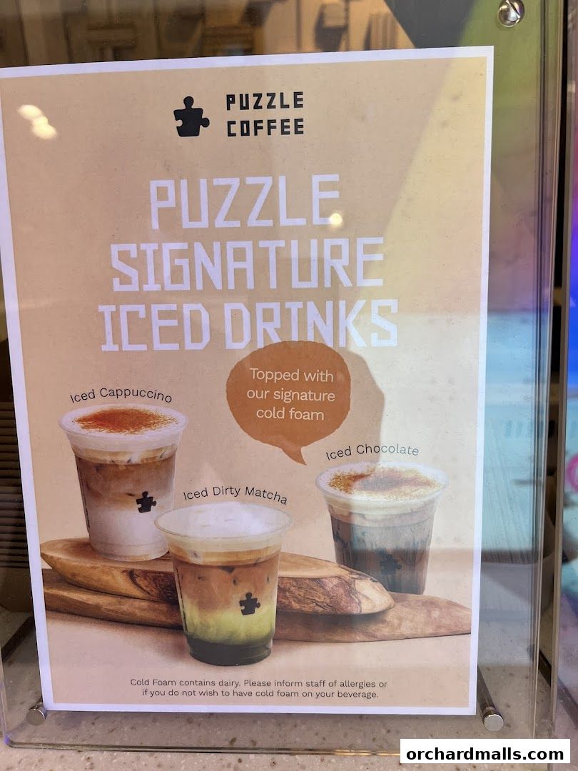 A sign showcasing Puzzle Coffee's signature iced drinks with cold foam.