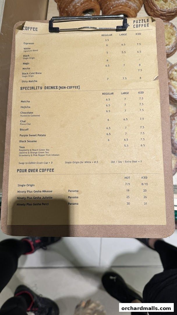 A menu board for Puzzle Coffee, featuring coffee and specialty drinks with prices.