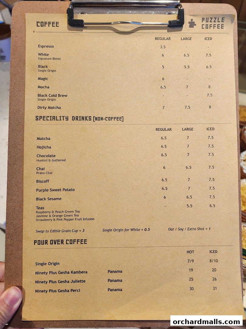 A menu board for Puzzle Coffee featuring coffee and specialty drinks with prices.