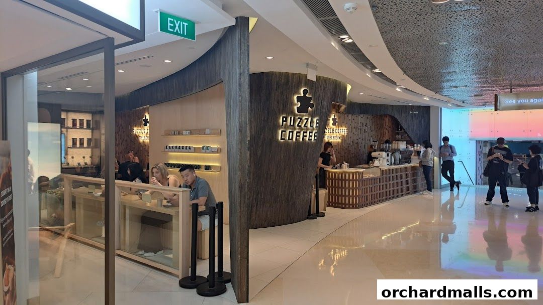 The interior of Puzzle Coffee shop with customers at the counter and seating area.