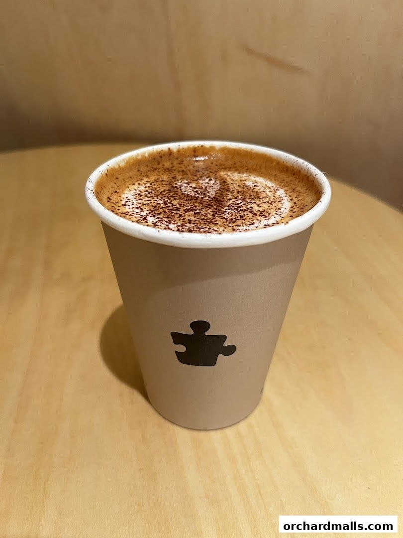 A close-up of a coffee cup with latte art and cocoa powder from Puzzle Coffee.