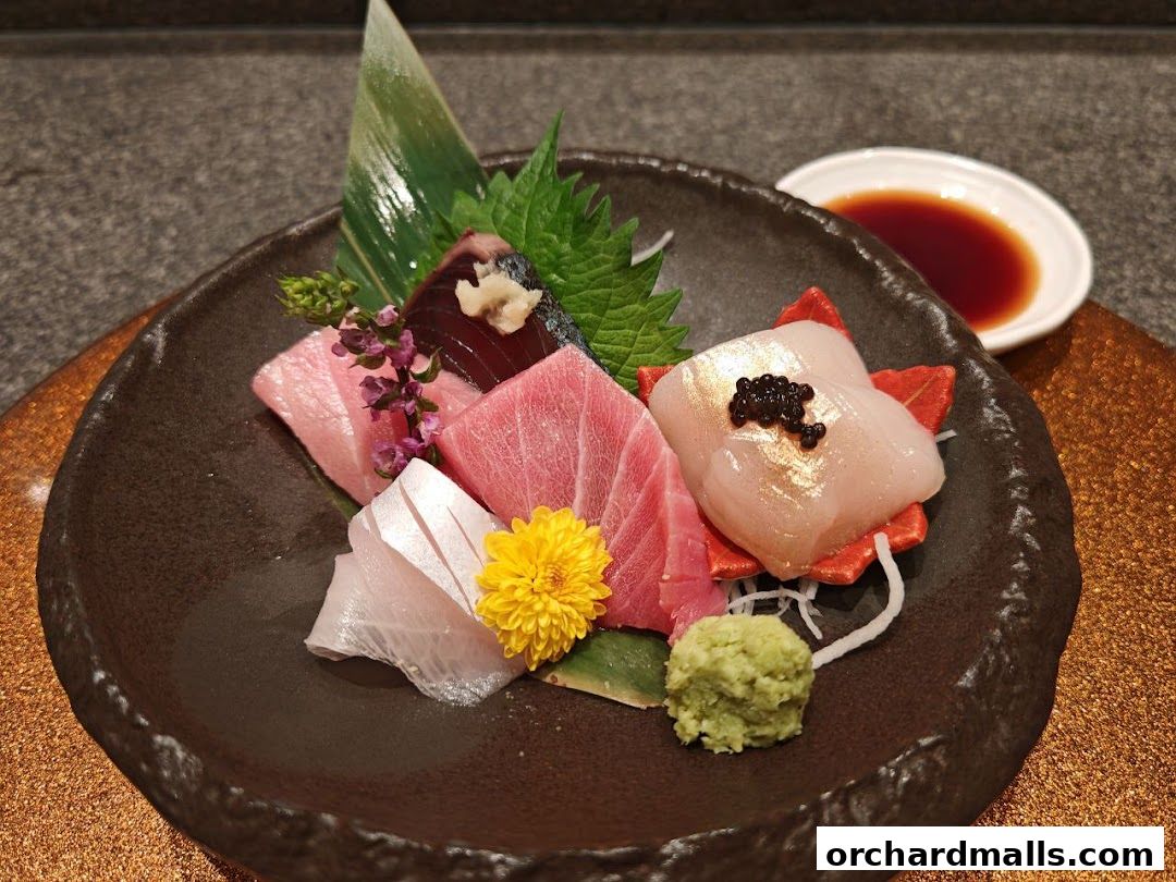 A beautifully presented sashimi platter with various types of fish, wasabi, and soy sauce.