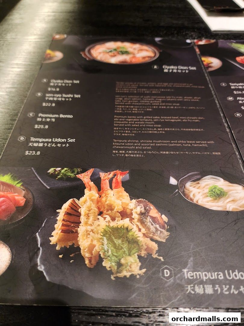 A close-up of a Japanese restaurant menu featuring various set meals with food photography.