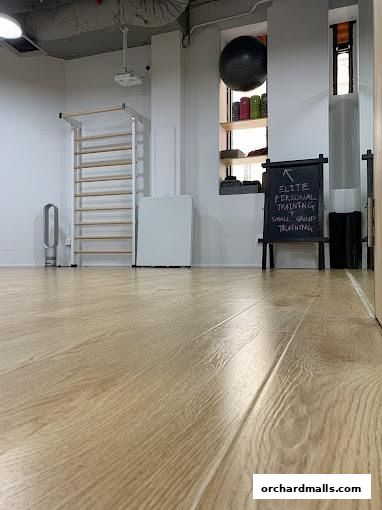 Interior of a personal training studio with gym equipment and a chalkboard sign.