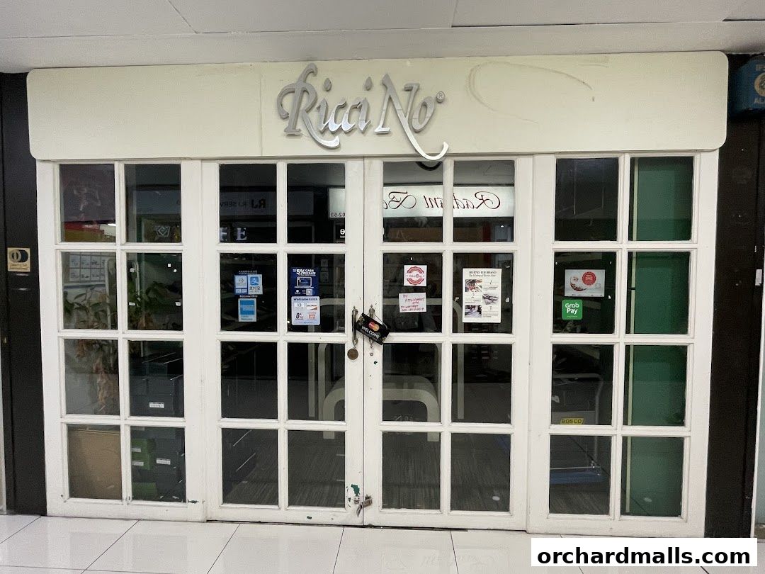 The entrance of Riccino shop with white double doors and glass panels.