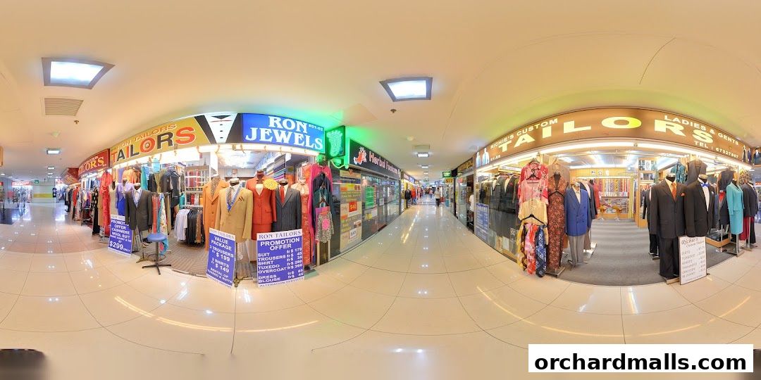 A panoramic view of a tailor shop with mannequins displaying suits and dresses.