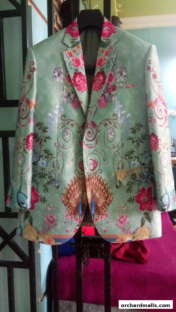 A light green blazer with a vibrant floral and peacock pattern.