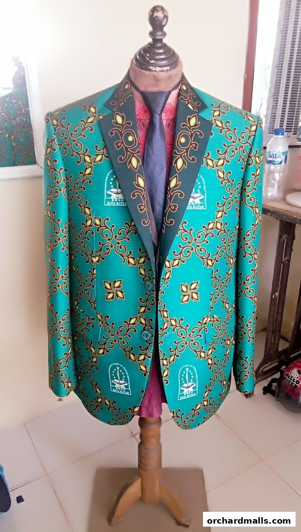 A custom-tailored teal blazer with a vibrant batik pattern displayed on a mannequin.