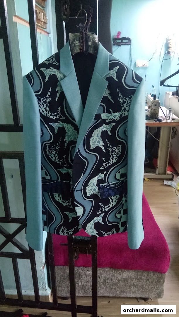 A custom-designed jacket with a unique fish pattern and light blue sleeves displayed on a mannequin.