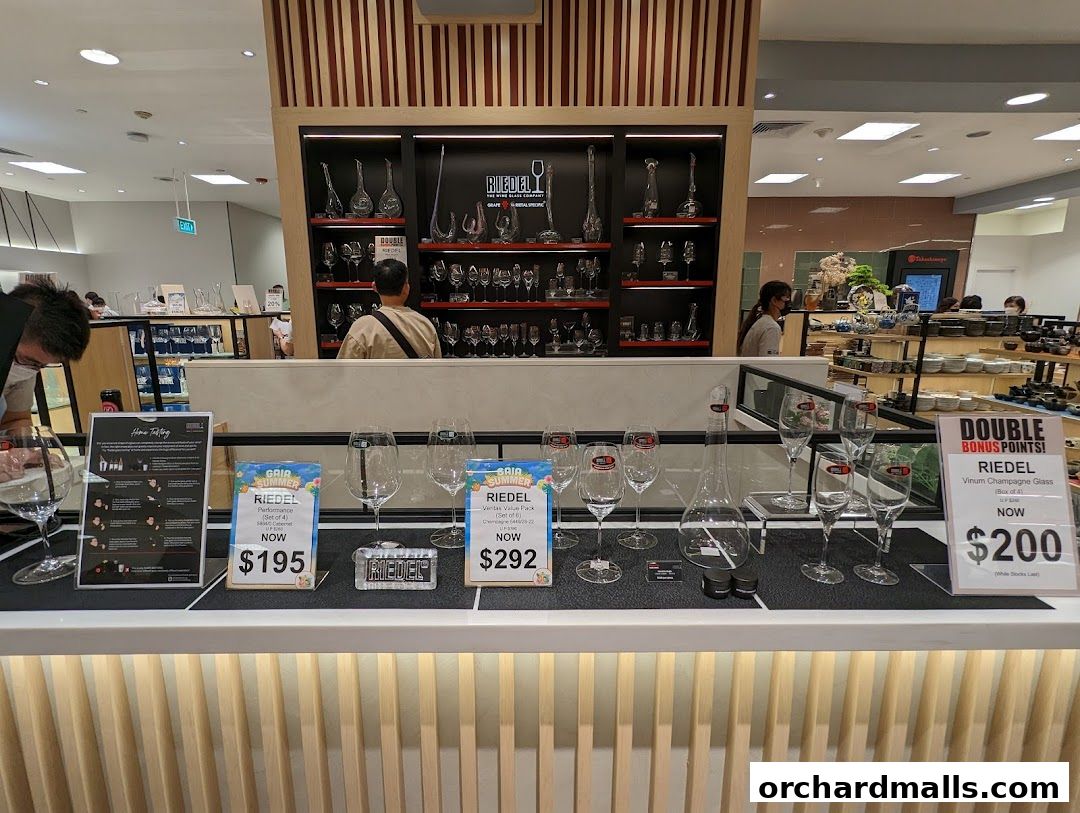 Riedel glassware display featuring wine glasses and decanters with promotional pricing.