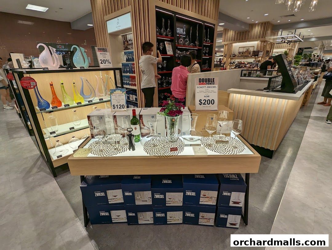 A display of Riedel and Schott Zwiesel glassware and wine accessories in a retail store.