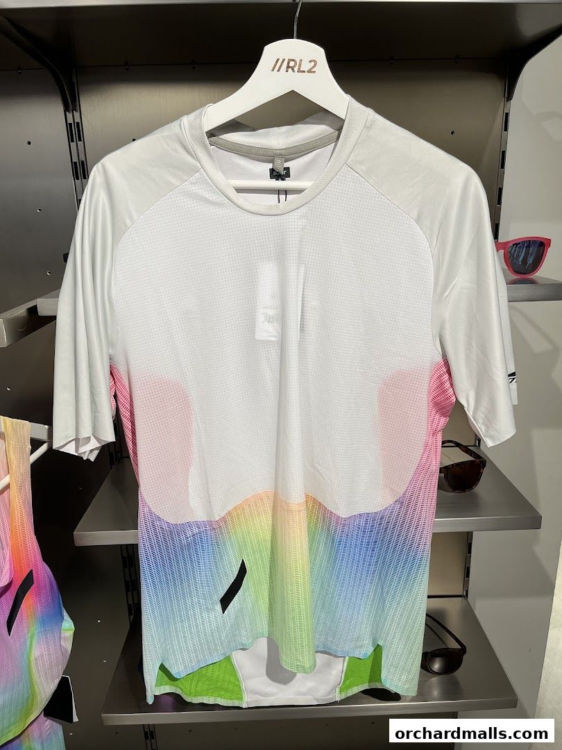 A white t-shirt with a rainbow gradient design is displayed on a hanger.