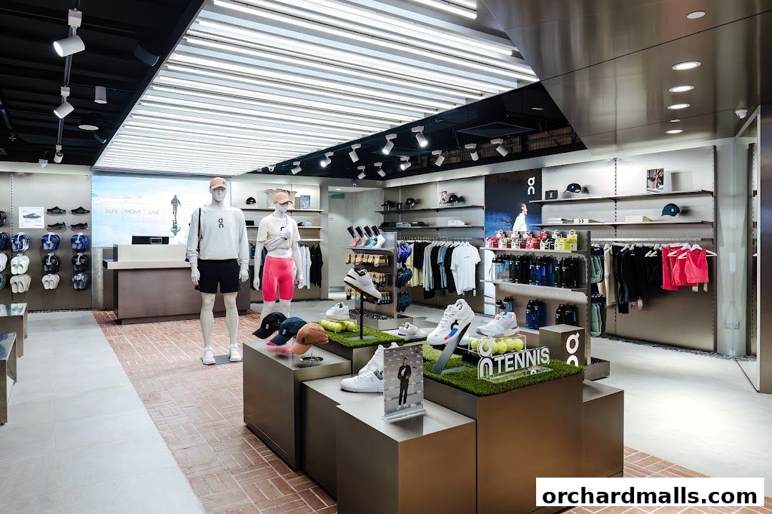 Interior of a modern sports apparel and footwear store with mannequins and merchandise displays.