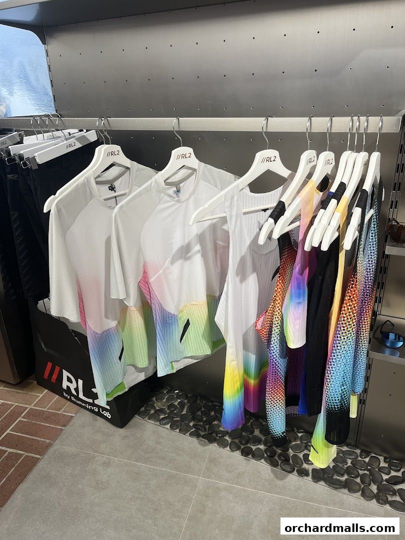 Colorful athletic apparel displayed on hangers inside a retail store.