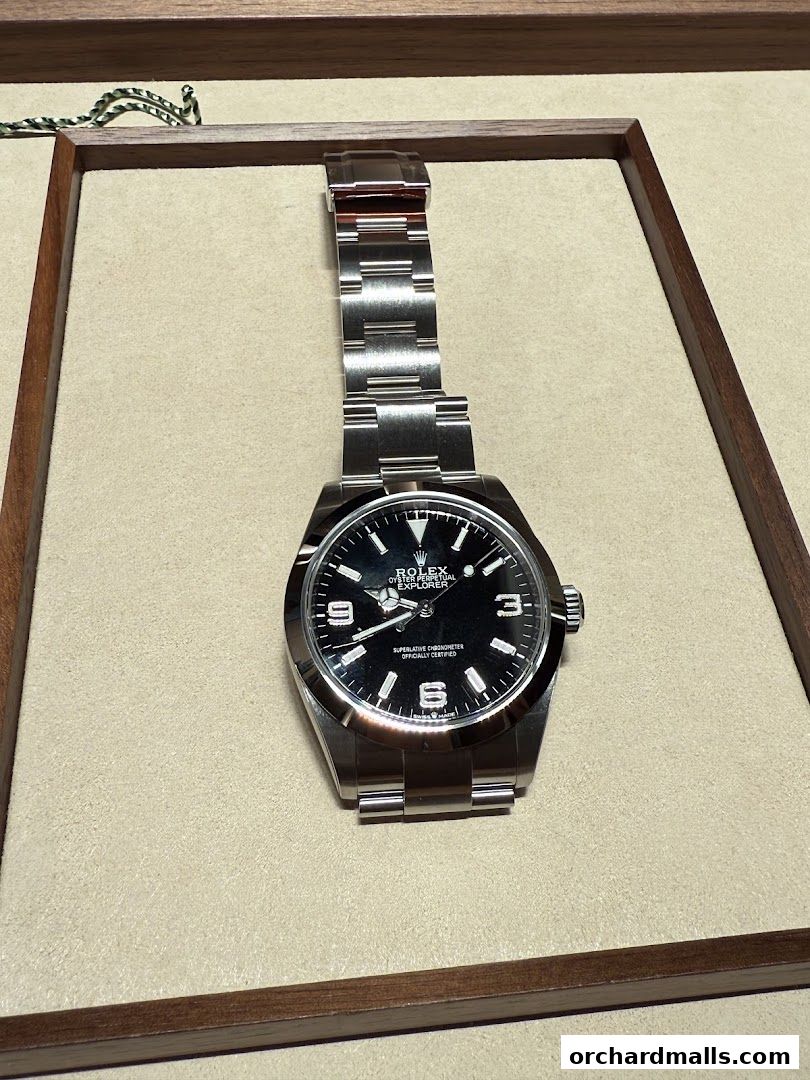 A close-up shot of a Rolex Explorer watch with a black dial and stainless steel bracelet.
