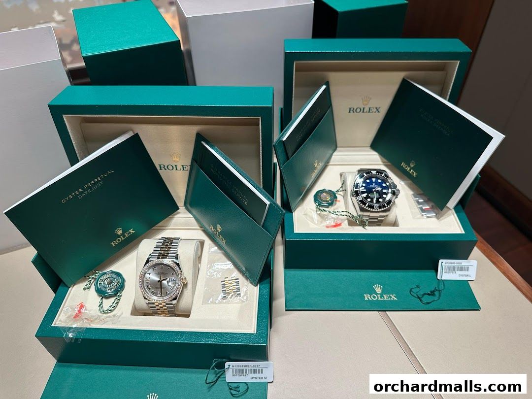 Two Rolex watches displayed in their signature green boxes with accompanying documentation.