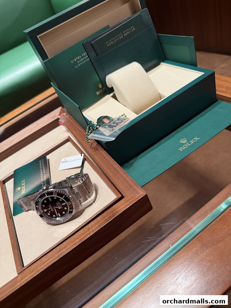 A Rolex Submariner watch displayed in its presentation box with warranty and manual.