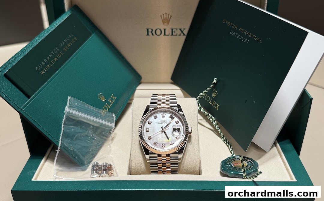 A Rolex Oyster Perpetual Datejust watch with diamond markers and a two-tone bracelet, presented in its box with documentation.