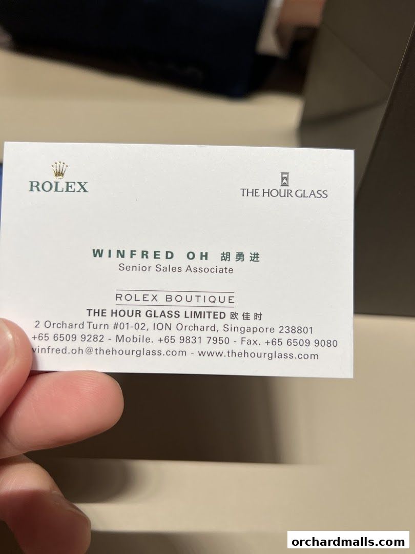 A business card for Winfred Oh, Senior Sales Associate at Rolex Boutique.