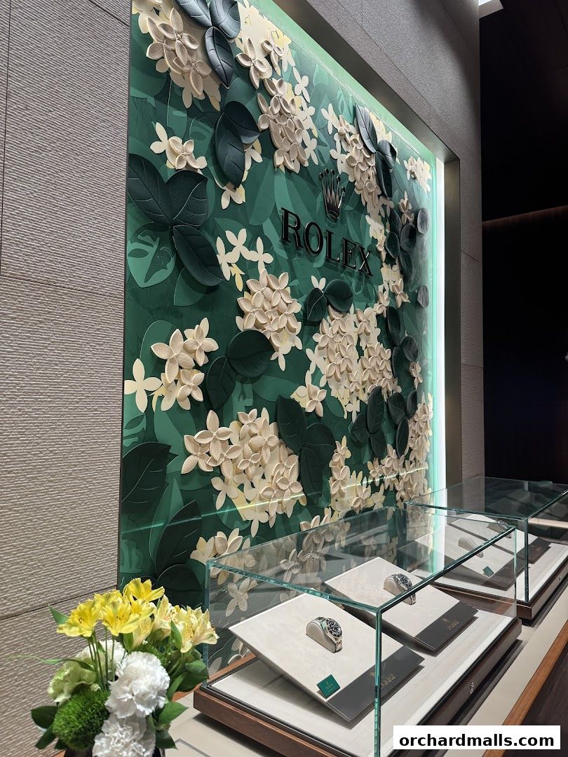 Rolex boutique interior with a floral-themed wall and display cases showcasing watches.