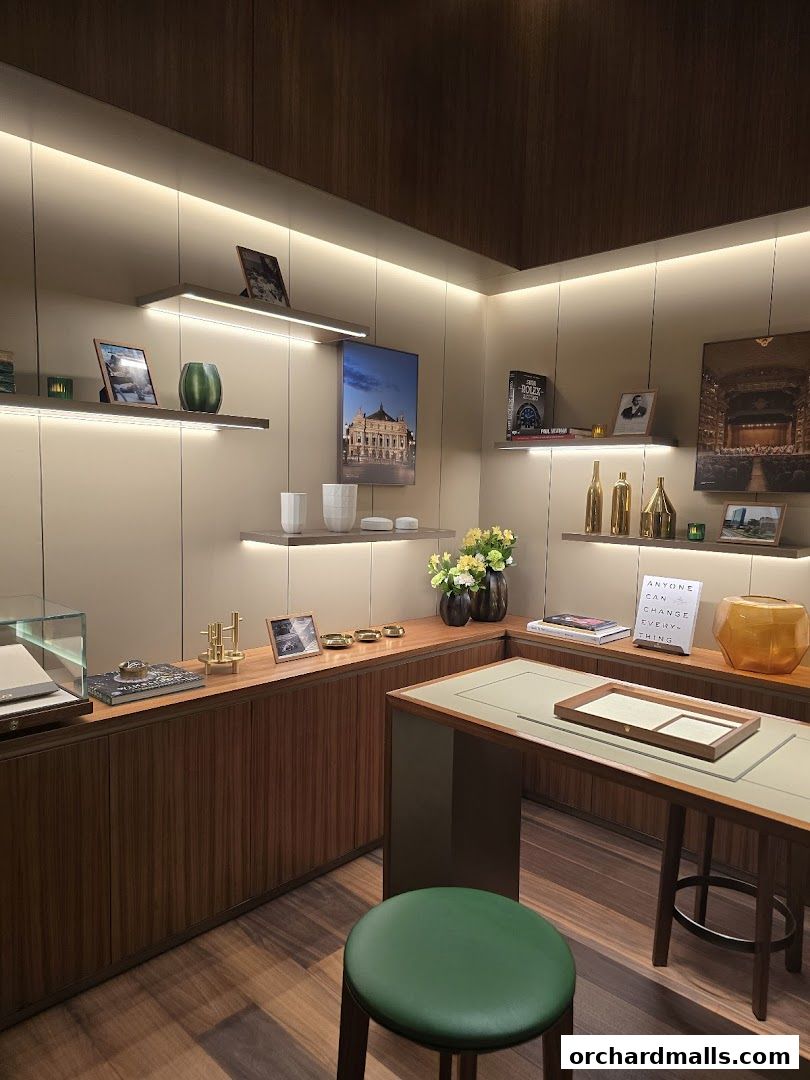 Interior of a luxury watch boutique with display shelves, a consultation desk, and seating.