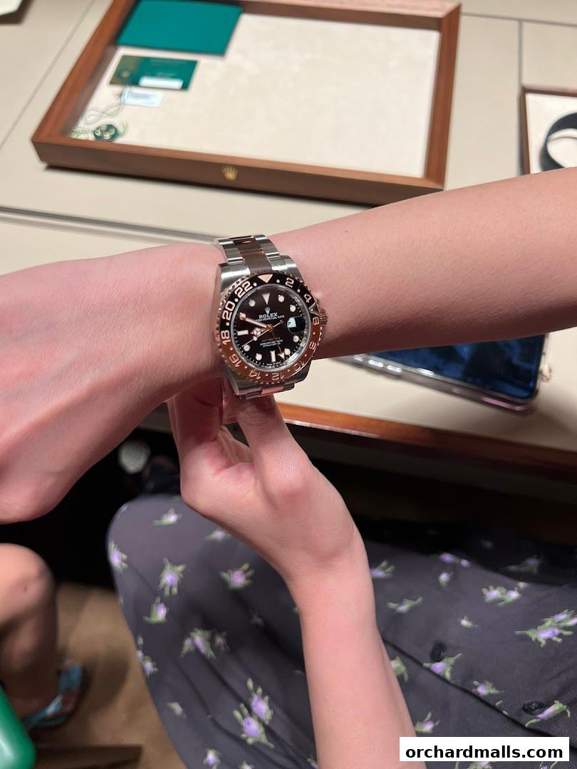 A person tries on a luxurious Rolex watch at a boutique.