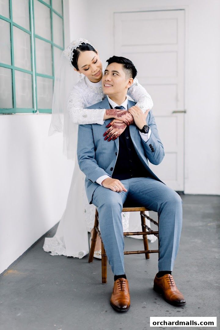 A bride in a white dress embraces a groom in a blue suit, both smiling.