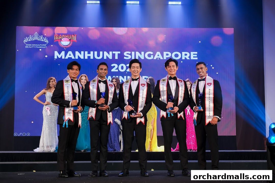 Winners of Manhunt Singapore 2024 beauty pageant on stage with trophies.