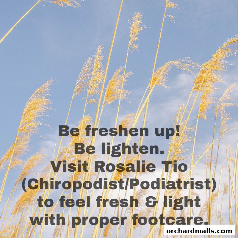 A serene image with tall grass against a blue sky, promoting footcare services.