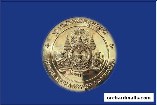 A golden emblem of the Royal Embassy of Cambodia on a blue background.