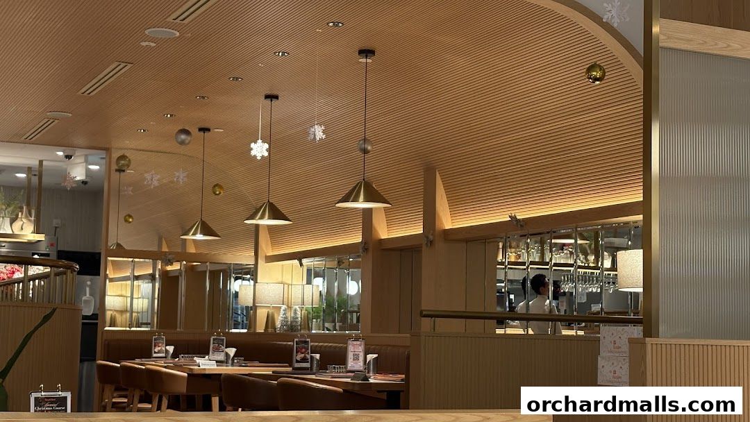 Interior of a restaurant with wooden decor, pendant lights, and dining tables set for guests.