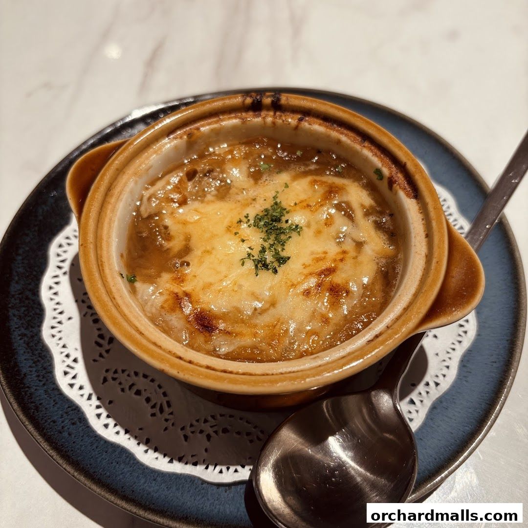 A close-up of a steaming bowl of French onion soup topped with melted cheese.