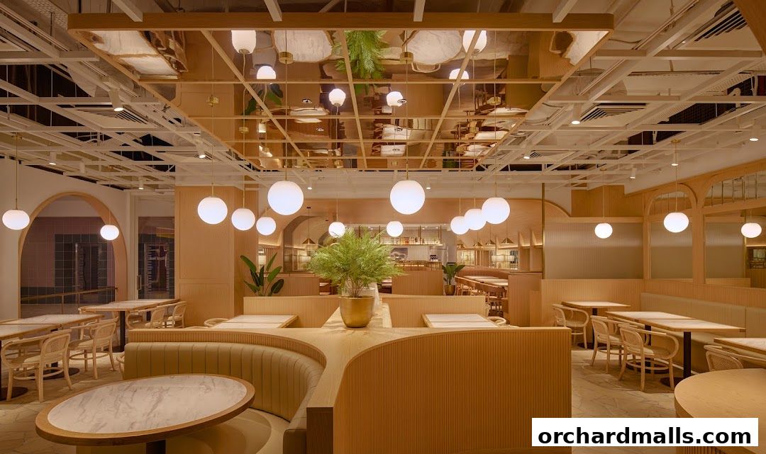Interior view of a modern restaurant with wooden booths, tables, and stylish pendant lighting.