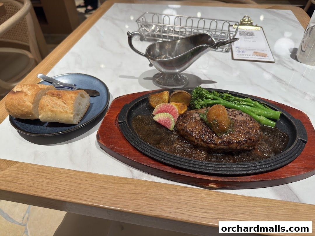 A delicious looking hamburger steak with sides of bread, potatoes, and broccoli.