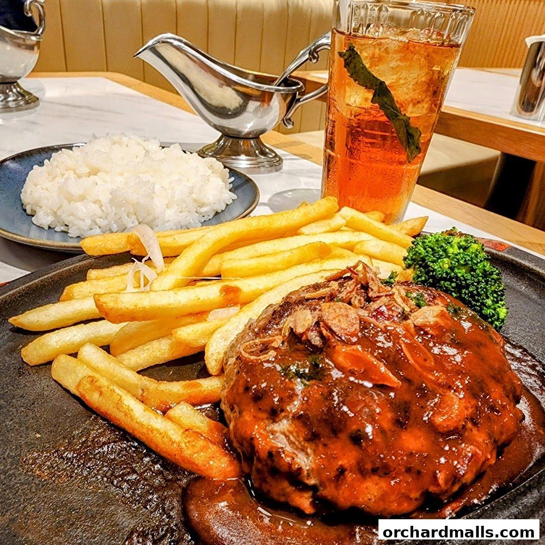 A delicious meal featuring a hamburger steak, french fries, rice, and a drink.