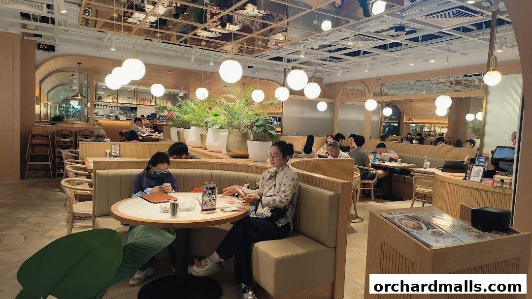 Interior of a modern restaurant with diners seated at tables and booths.