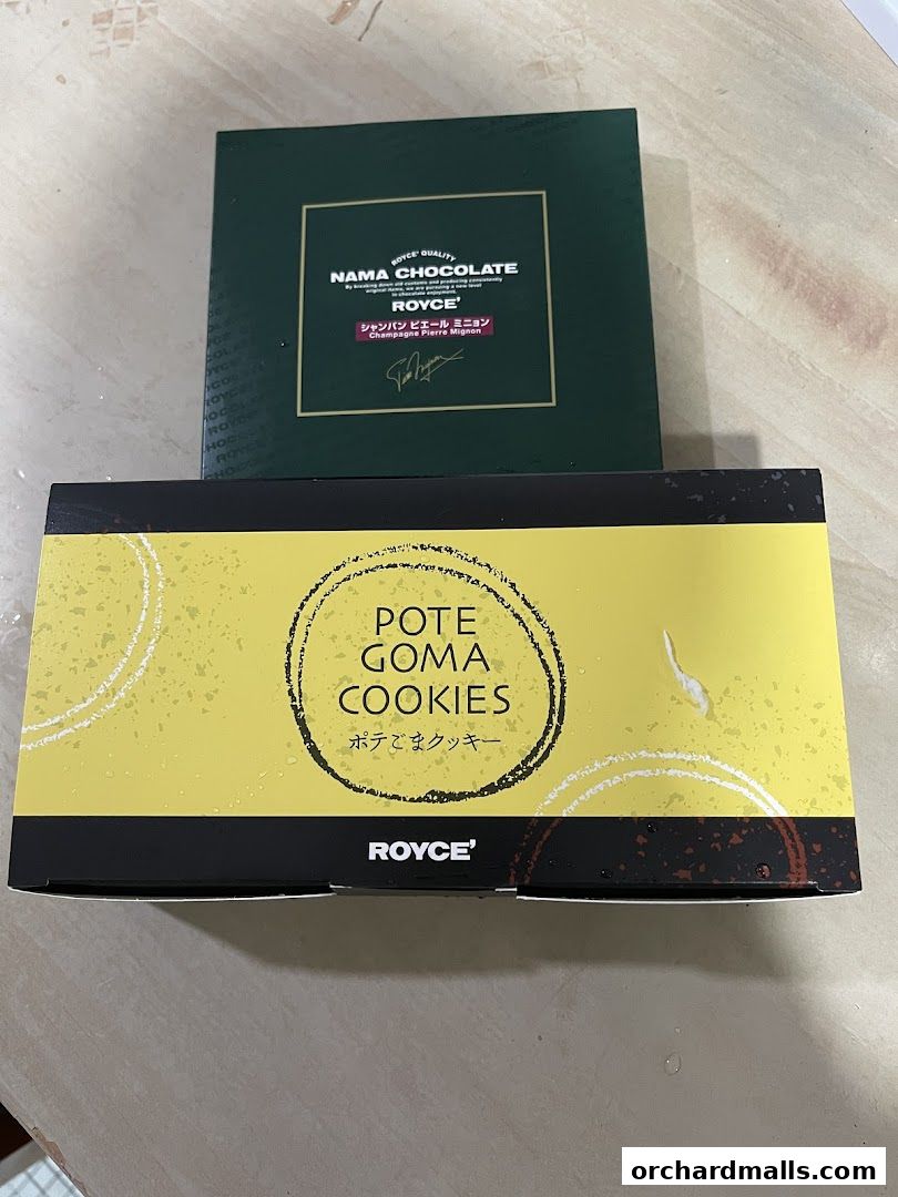 Two boxes of Royce' chocolates and cookies are displayed on a surface.